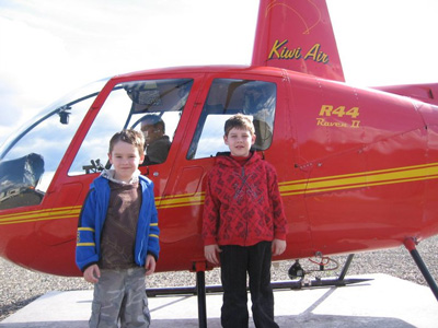 Kids pose next to helicopter before a tour into Hells Canyon